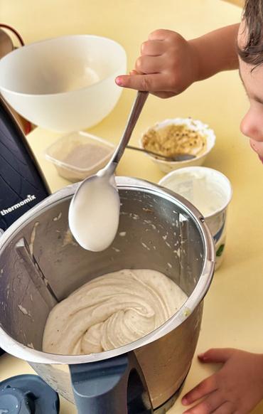 Auf diesem Bild sieht man ein Kind was Eis zubereitet.