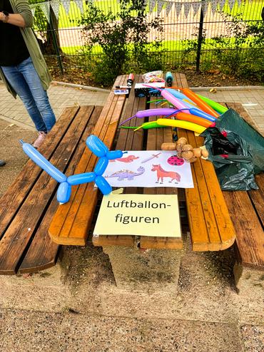 Auf diesem Bild ist ein Basteltisch mit Luftballons zu sehen.