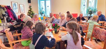 Auf diesem Bild kann man die Gäste unserer Weihnanchtsfeier sehen. Die Stimmung ist festlich und der generationsübergreifende Aspekt besonders gut zu erkennen.