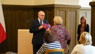 Auf diesem Bild sieht man wie Frau Kraus das Herz an den Bürgermeister überreicht.