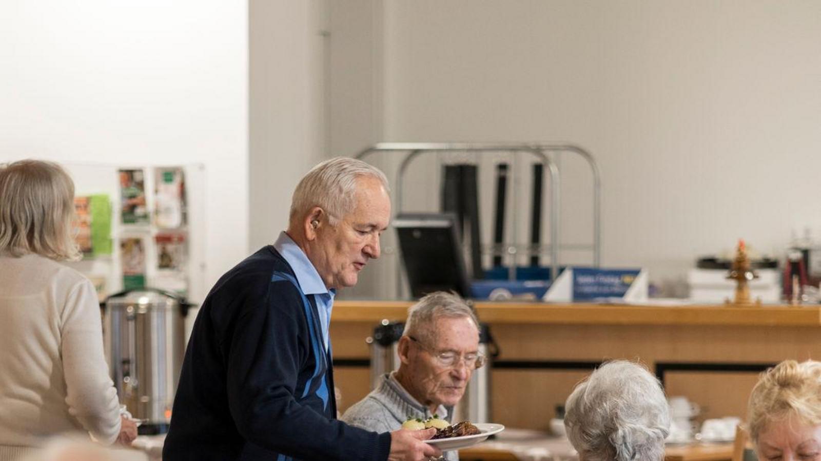 Auf diesem Bild ist das festliche Weihnachtsessen und die Gäste zu sehen.