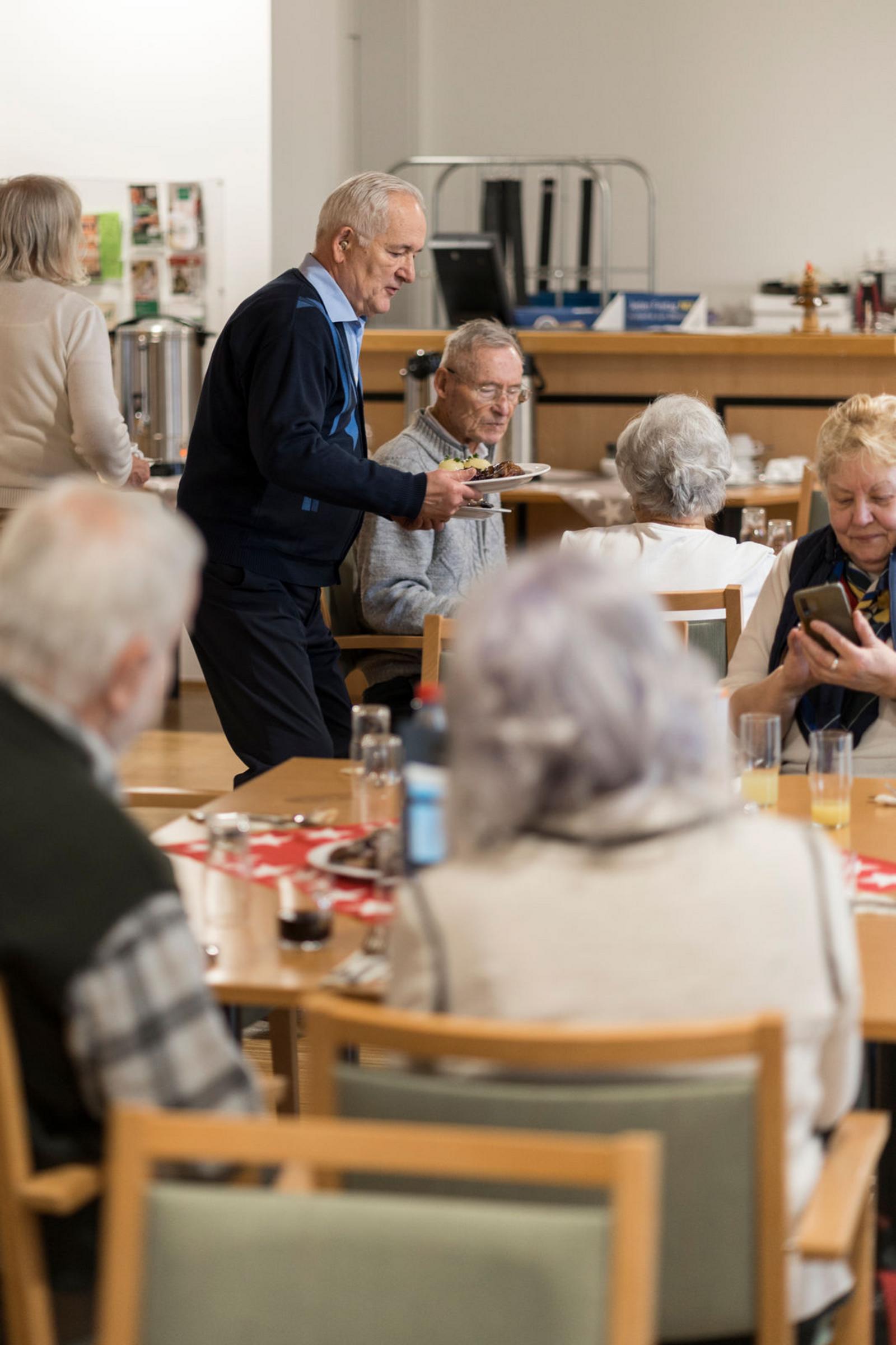 Auf diesem Bild ist das festliche Weihnachtsessen und die Gäste zu sehen.