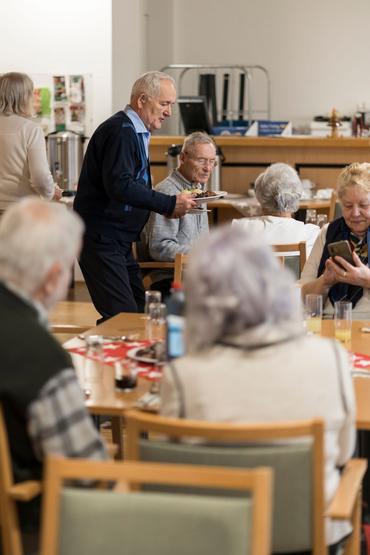 Auf diesem Bild ist das festliche Weihnachtsessen und die Gäste zu sehen.