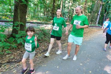 Auf diesem Bild ist eine junge Familie mit Vosi-Laufshirts zu sehen.