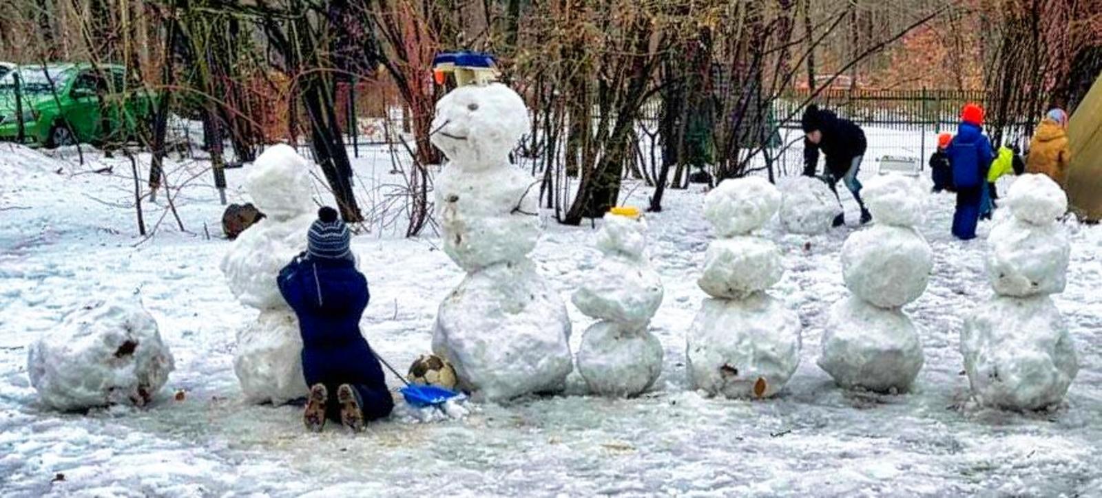 Auf diesem Bild sieht man die Kinder, wie Sie Schneeskulpturen Bauen.
