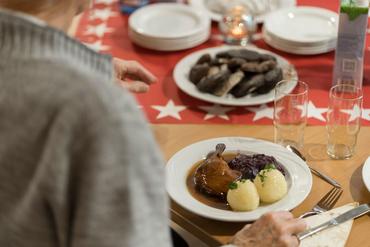 Auf diesem Bild ist das festliche Weihnachtsessen und die Gäste zu sehen.