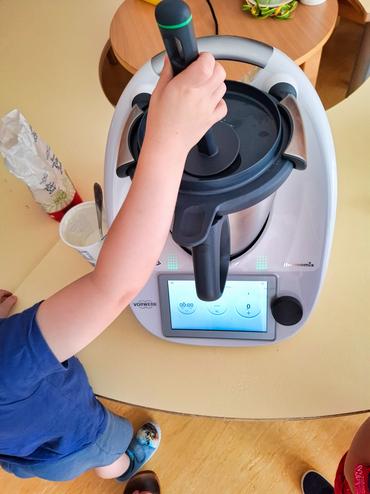 Auf diesem Bild sieht man wie ein Kind das Eis zubereitet.