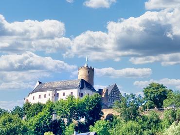 Auf dem Bild ist ein Panoramablick auf die Burg Scharfenstein zu sehen. Das Wetter ist prächtig.