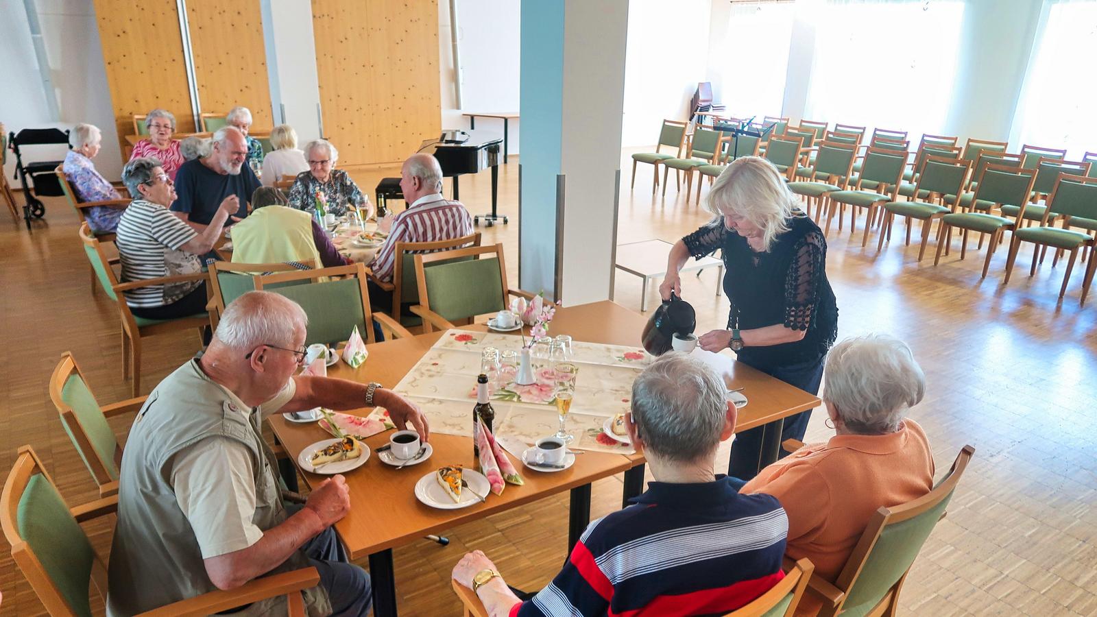 Auf diesem Bild sieht man einige Gäste, an einem Tisch sitzend. Diese werde von einer Mitarbeiterin bedient welche Ihnen Kaffee einschänkt.
