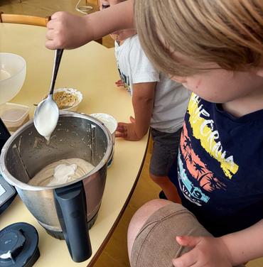 Auf deisem Bild sieht man wie ein Kind das Eis zubereitet.
