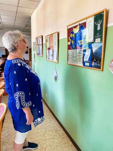 Auf diesem Bild sind einige antike Speisekarten zu sehen. Sie werden von einer Besucherin bewundert.