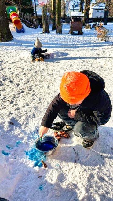 Auf dem Bild sieht man, wie Kinder im Schnee spielen.