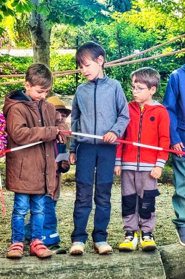 Auf diesem Bild sind 3 Kinder zu sehen welche sich gespannt mit dem Klettergerüst beschäftigen.