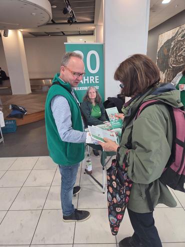 Auf diesem Bild vermittelt einer unserer Mitarbeiter unser Dienstleistungsspektrum an eine Passantin