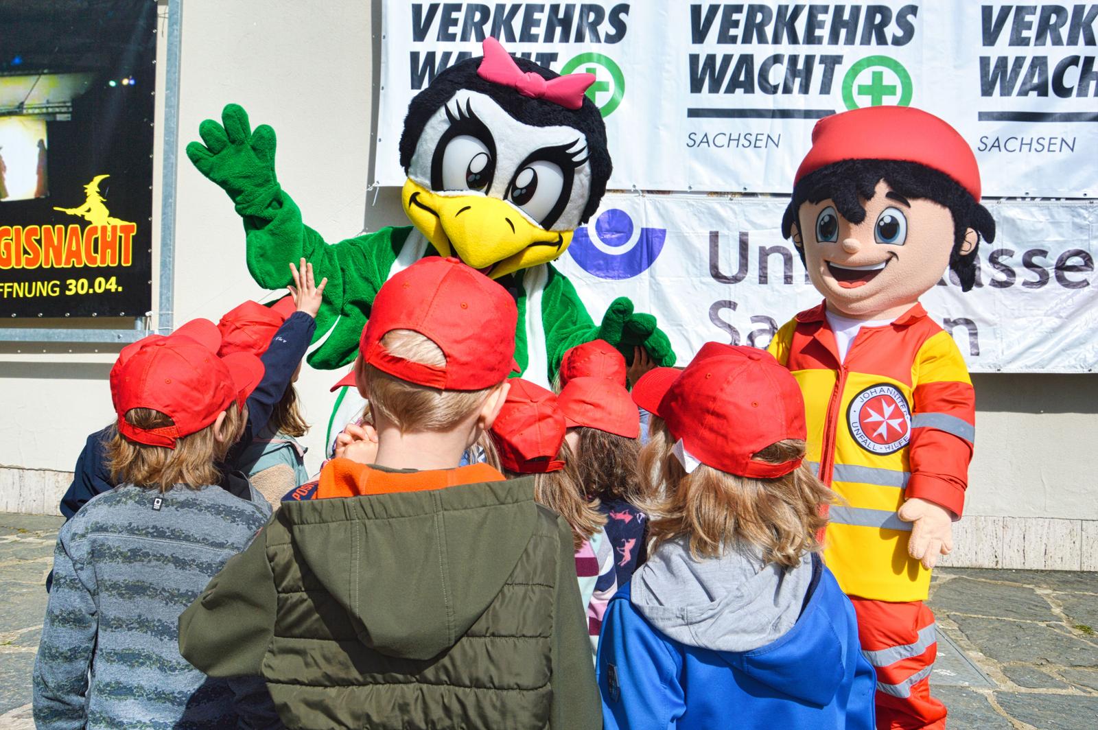 Auf diesem Bild sind die Kinder und die Maskottchen zu sehen.