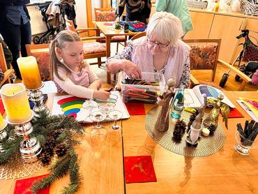 Auf diesem Bild kann man die Gäste unserer Weihnanchtsfeier sehen. Die Stimmung ist festlich und der generationsübergreifende Aspekt besonders gut zu erkennen.