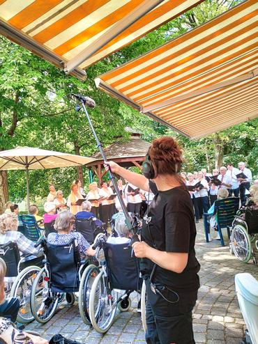 Auf diesem Bild sieht man einen Kameramann vom ZDF welcher den Chor filmt. 