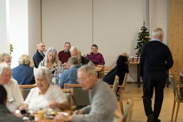 Auf diesem Bild ist das festliche Weihnachtsessen und die Gäste zu sehen.