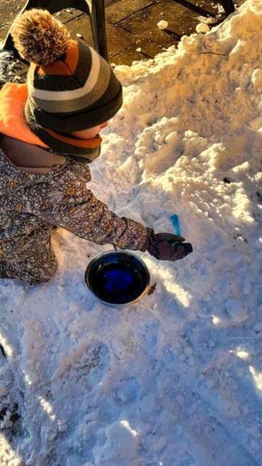 Auf dem Bild sieht man, wie Kinder im Schnee spielen.