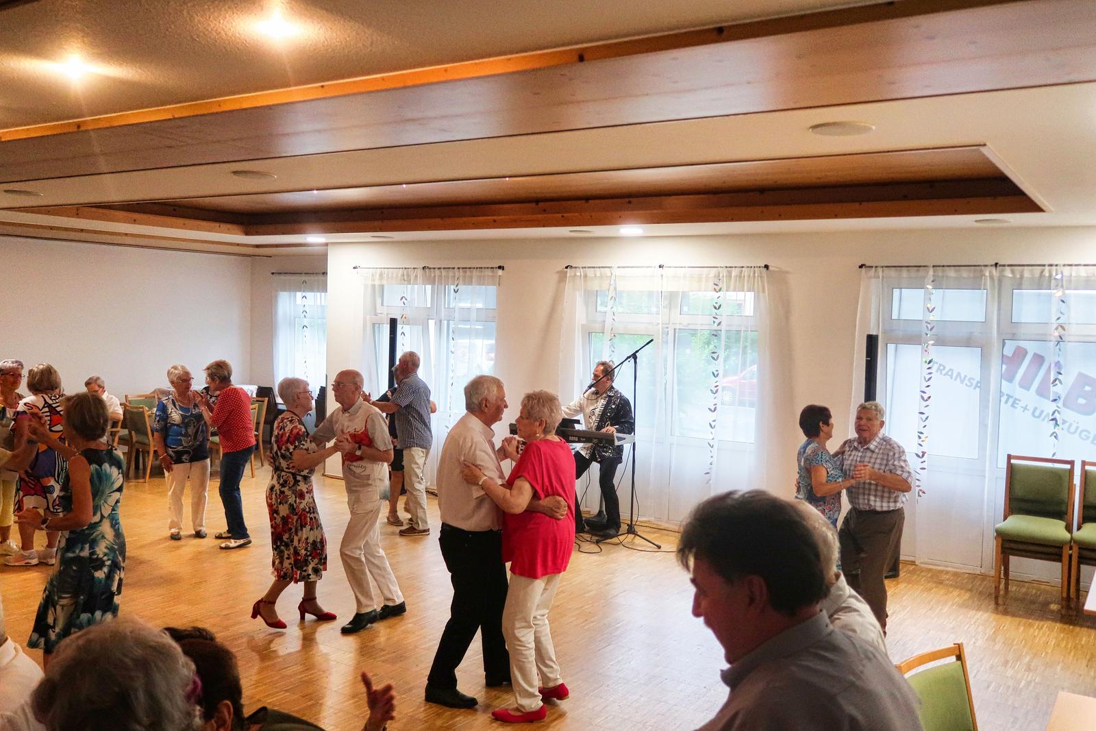 Auf diesem Bild sind viele tanzende Menschen zu erkennen. Die Stimmung ist ausgelassen.
