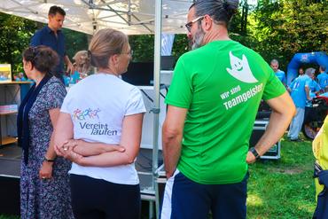 Auf diesen Bild sind zwei Teilnehmer des Laufes zu sehen. Die Logos stehen dabei im Mittelpunkt.