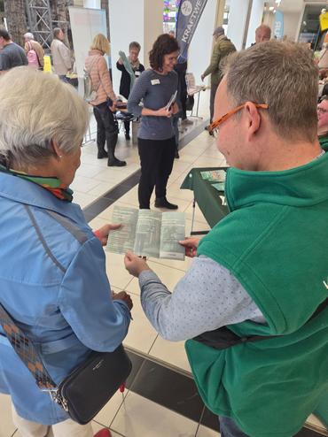 Auf diesem Bild vermittelt einer unserer Mitarbeiter unser Dienstleistungsspektrum an eine Passantin.