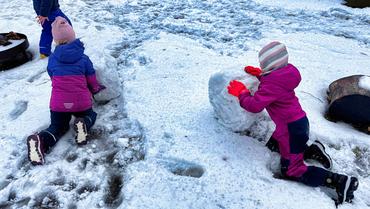 Auf diesem Bild sieht man die Kinder, wie Sie Schneeskulpturen Bauen.