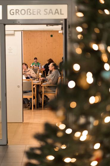 Auf diesem Bild ist das festliche Weihnachtsessen und die Gäste zu sehen.