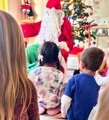 Auf diesem Bild ist der Weihnachtsmann und die Kinder zu sehen.