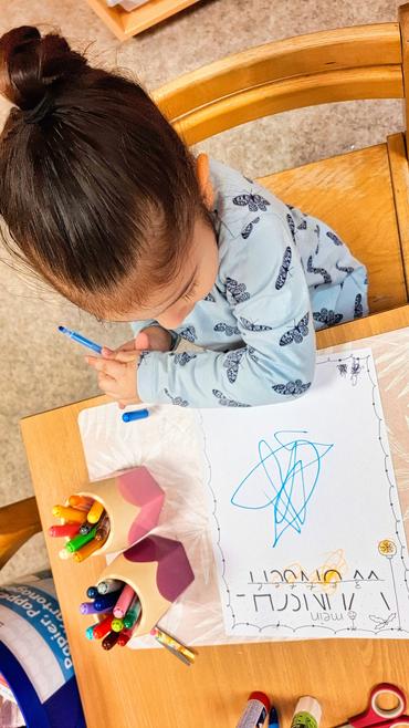 Auf diesem Bild sieht man, wie ein Kind einen Wusnschzettel schreibt.